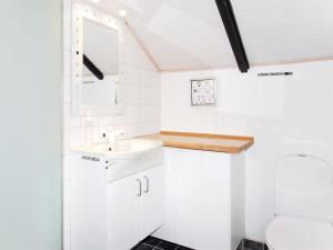 La petite salle de bains est pourvue d'un lavabo et de toilettes. dans l'établissement Holiday Home Beneta - 300m from the sea in Western Jutland by Interhome, à Hvide Sande