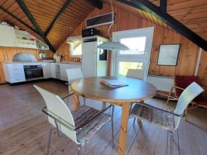 uma mesa de jantar e cadeiras numa cozinha em Holiday Home Beneta - 300m from the sea in Western Jutland by Interhome em Hvide Sande