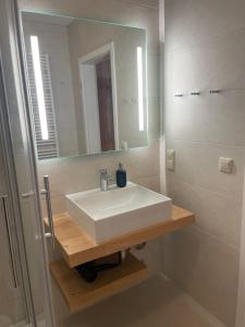 a bathroom with a white sink and a mirror at Ferienwohnung im Alten Postamt in Binz in Binz +8 photos