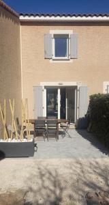 un patio con mesa y sillas frente a un edificio en Maisonnette des Vignes, en Calvisson