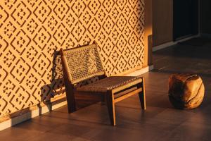 a wooden chair sitting in front of a wall at Tulum Beach Resort Dakhla in Dakhla