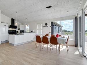 eine Küche und ein Esszimmer mit Tisch und Stühlen in der Unterkunft Holiday Home Alvhild - from the sea by Interhome in Ringkøbing + 17 Fotos