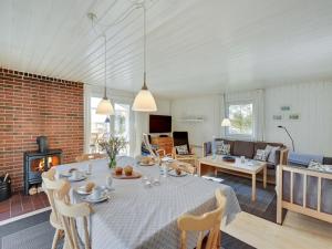 a dining room and living room with a table and a fireplace at Holiday Home Shalez - from the sea in Western Jutland by Interhome in Bjerregård