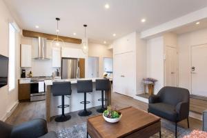 a kitchen and living room with a table and chairs at Brand New Light filled Mile End Flat by Denstays in Montréal