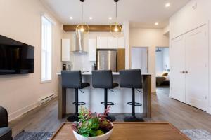 a kitchen with a table and chairs in a room at Brand New Light filled Mile End Flat by Denstays in Montréal