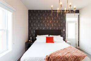 - une chambre avec un grand lit blanc et un oreiller rouge dans l'établissement Brand New Light filled Mile End Flat by Denstays, à Montréal