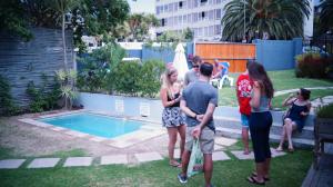 a group of people standing around a swimming pool at Atlantic Point Backpackers in Cape Town