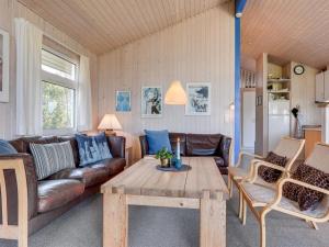 a living room with a couch and a table at Holiday Home Andrie - 800m from the sea in Western Jutland by Interhome in Hvide Sande