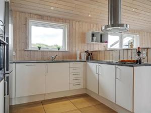 una cocina con armarios blancos y fregadero en Holiday Home Frido - 400m from the sea in NW Jutland by Interhome en Torsted