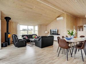 sala de estar con mesa, sillas y chimenea en Holiday Home Frido - 400m from the sea in NW Jutland by Interhome en Torsted