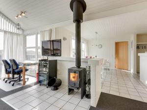 a fireplace in a living room with a table and chairs at Holiday Home Gottfreda - 330m to the inlet in Western Jutland by Interhome in Havrvig