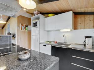 a kitchen with white cabinets and a counter top at Holiday Home Friedel - 150m from the sea in Western Jutland by Interhome in Hvide Sande