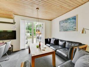 a living room with a couch and a table at Holiday Home Thana - 1-4km from the sea by Interhome in Ulfborg