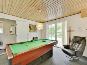 a billiard room with a pool table and a chair at Holiday Home Thana - 1-4km from the sea by Interhome in Ulfborg