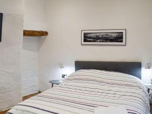 a bed in a bedroom with a picture on the wall at Hogwood Cottage in Knaresborough