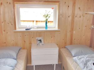 een slaapkamer met 2 bedden, een raam en een tafel bij Holiday Home Beatrice - 150m from the sea in Western Jutland by Interhome in Lemvig
