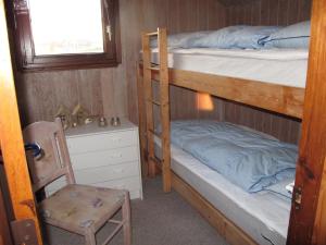 een slaapkamer met 2 stapelbedden en een stoel bij Holiday Home Beatrice - 150m from the sea in Western Jutland by Interhome in Lemvig