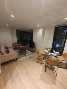 sala de estar con sofá, mesa y sillas en Lovely 2Bedroom Apartment en Mánchester