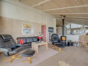 a living room with a couch and chairs and a table at Holiday Home Rajna - 95m to the inlet by Interhome in Lemvig