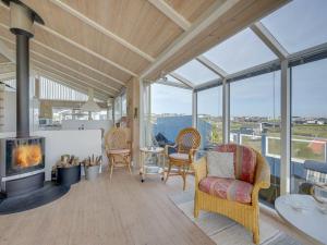 a living room with a fireplace and glass windows at Holiday Home Rajna - 95m to the inlet by Interhome in Lemvig