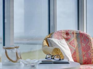 a table with a book and a pair of glasses at Holiday Home Rajna - 95m to the inlet by Interhome in Lemvig