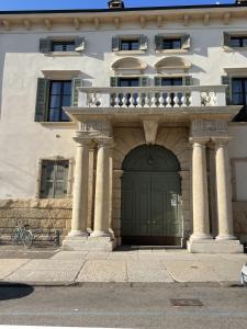 budynek z zielonymi drzwiami i balkonem w obiekcie Antiche Colonne w Weronie