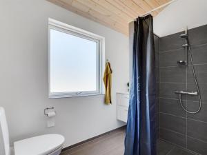 a bathroom with a shower and a toilet and a window at Holiday Home Gyrial - 950m from the sea by Interhome in Torsted