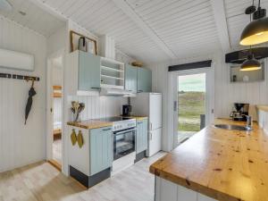 une cuisine avec des placards bleus et un comptoir en bois dans l'établissement Holiday Home Mads - 950m from the sea in NW Jutland by Interhome, à Torsted