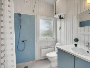 La salle de bains est pourvue d'une douche, de toilettes et d'un lavabo. dans l'établissement Holiday Home Mads - 950m from the sea in NW Jutland by Interhome, à Torsted