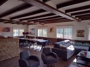 a living room with a couch and a table and chairs at Gîtes BEL'M in La Bresse