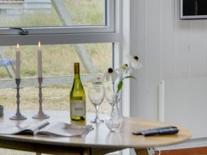 uma mesa com uma garrafa de vinho e dois copos em Holiday Home Luzy - 600m from the sea in NW Jutland by Interhome em Torsted
