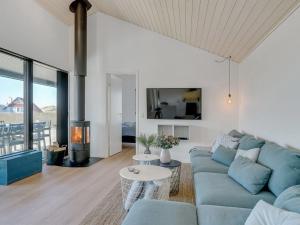 sala de estar con sofá azul y chimenea en Holiday Home Aiko - 50m from the sea in NW Jutland by Interhome, en Torsted