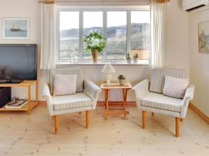 sala de estar con 2 sillas y TV en Holiday Home Ali - 75m from the sea in Western Jutland by Interhome, en Harboør
