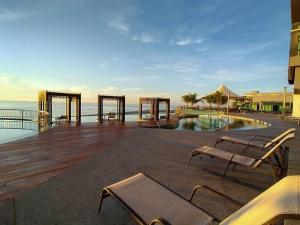 una terraza con banco y piscina en Best Moments Studio City - Imperium Residence, en Kuantan