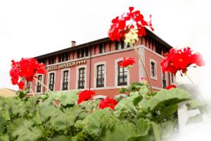 a building with red flowers in front of it at Imperion in Cangas de Onís