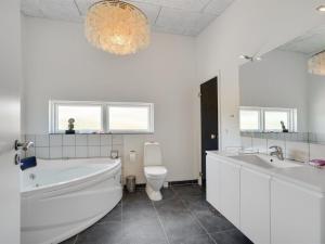 uma casa de banho com uma banheira, um WC e um lavatório. em Holiday Home Julika - 400m from the sea in NW Jutland by Interhome em Torsted