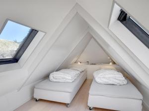 2 Betten im Dachgeschoss mit weißen Decken in der Unterkunft Holiday Home Tabea - 150m from the sea in NW Jutland by Interhome in Løkken