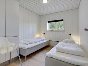 2 bedden in een witte kamer met een raam bij Holiday Home Øthbiorn - 1-1km from the sea in NW Jutland by Interhome in Løkken