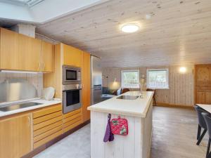 a kitchen with wooden cabinets and a counter top at Holiday Home Anegrete - 900m from the sea in NW Jutland by Interhome in Torsted
