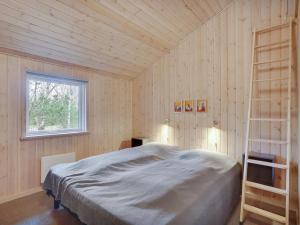 a bedroom with a bed and a ladder in it at Holiday Home Anegrete - 900m from the sea in NW Jutland by Interhome in Torsted