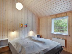 a bedroom with a bed in a room with a window at Holiday Home Anegrete - 900m from the sea in NW Jutland by Interhome in Torsted