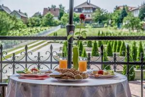 una mesa con platos de comida en la parte superior de un balcón en Laky Villa Zalakaros en Zalakaros