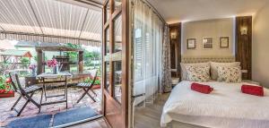 a bedroom with a bed and a balcony with a table at Laky Villa Zalakaros in Zalakaros