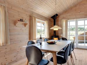 comedor con paredes de madera, mesa y sillas en Holiday Home Eggerich - 900m from the sea in NW Jutland by Interhome, en Torsted