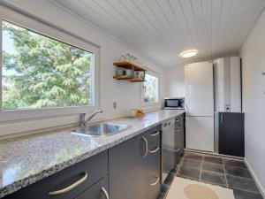 eine Küche mit einer Spüle und einem Kühlschrank in der Unterkunft Holiday Home Kanerva - 350m from the sea in NW Jutland by Interhome in Torsted