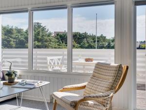 Habitación con silla, mesa y ventanas en Holiday Home Kanerva - 350m from the sea in NW Jutland by Interhome, en Torsted