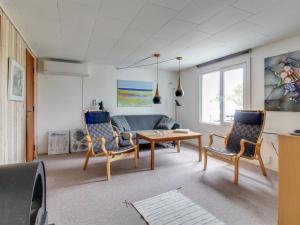 a living room with a couch and a table and chairs at Holiday Home Avelin - 800m from the sea in NW Jutland by Interhome in Torsted