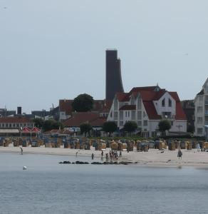 a group of people walking on a beach with houses at 470er Ferienwohnung in Laboe