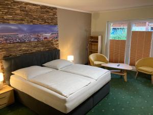 - une chambre avec un grand lit et un mur en briques dans l'établissement Ferienhaus am Mühlenberg, à Waren