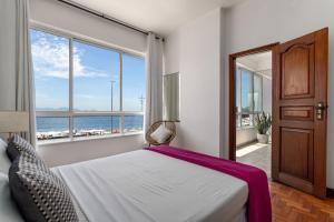 1 dormitorio con 1 cama y vistas al océano en Sofisticado em Copacabana - Vista para praia - A403 Z3, en Río de Janeiro
